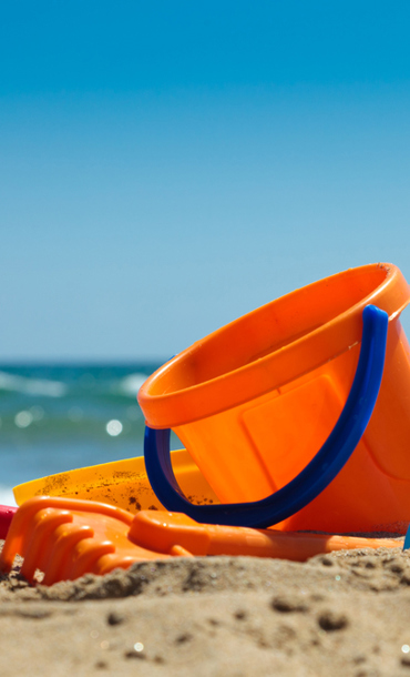 Plastic bucket and spades on a beach