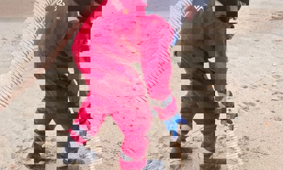 Man with specialist equipment to hoover debris from beach 