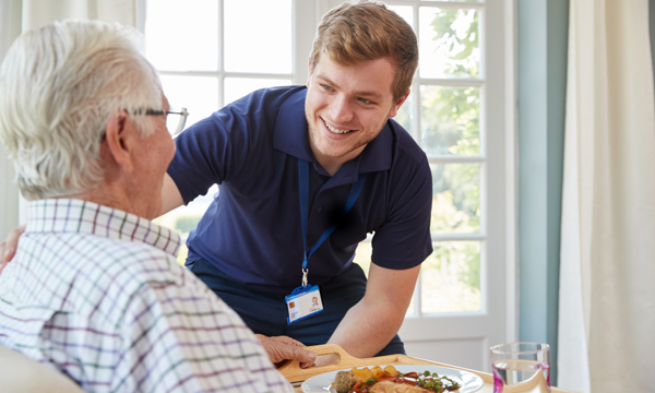 A male nurse looking at an elderly male