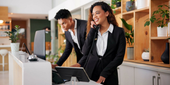 A woman on the phone and a man looking at a computer screen.