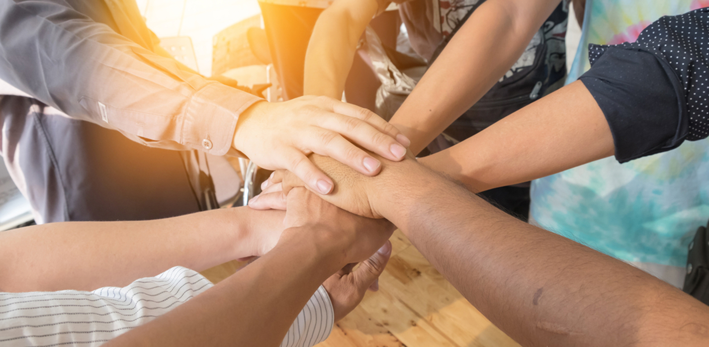 nojs Group of people in a circle with hands joined in the centre