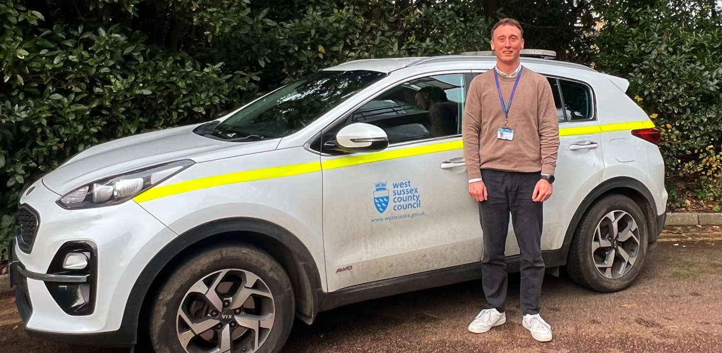nojs Leon standing next to a car
