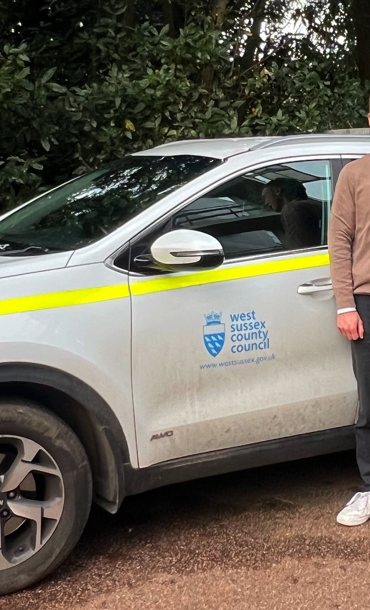 Leon standing next to a car