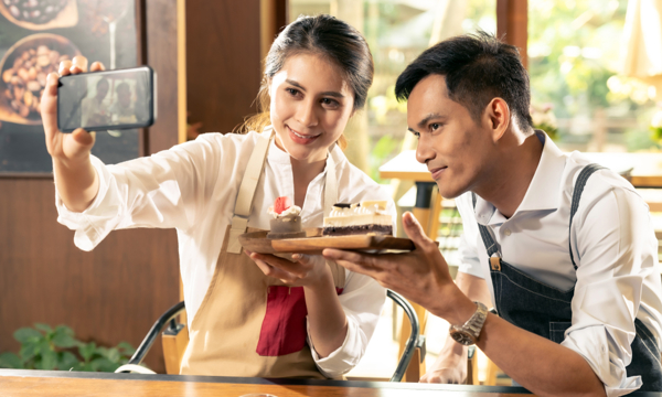 2 people smiling for a selfie with a phone