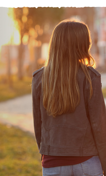 Two young women chatting while walking on a path.