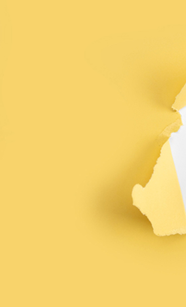 Yellow background with a small torn hole showing a black plus symbol on white.