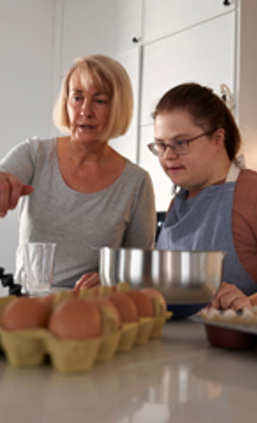 Two women cooking in a kitchen.