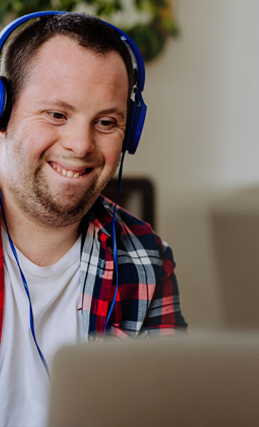 A young smiling man wearing headphones.