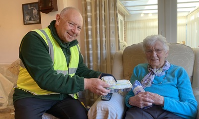 Mrs Barbara Platt, 93, receiving her wheat bag from community team member Phil Cooling.