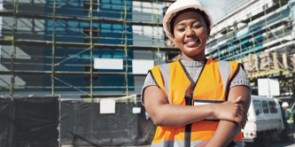 Young, female, Black, happy Standing in front of scaffolding on buildings 