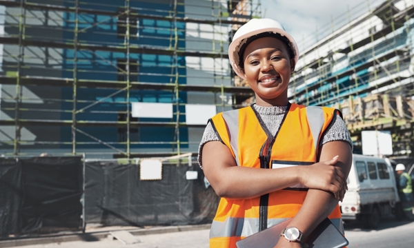 Young, female, Black, happy Standing in front of scaffolding on buildings 