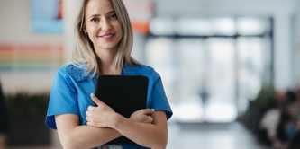 A female nurse holding a clipboard