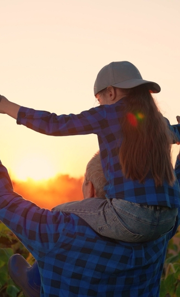 A child sitting on their father's shoulders.