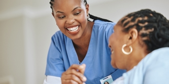 Female patient and female nurse laughing together.