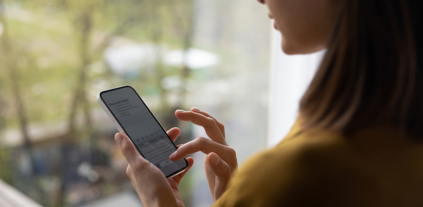 nojs A young woman sending a text message on her mobile phone.