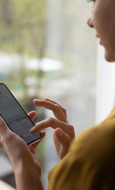 A young woman sending a text message on her mobile phone.