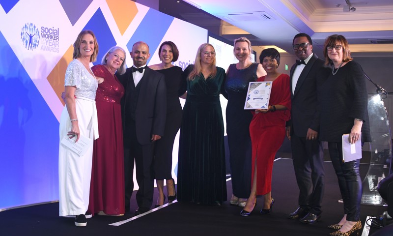 Nine people from the county council's Children, Young People and Learning team stand on stage together after being presented with the silver award.