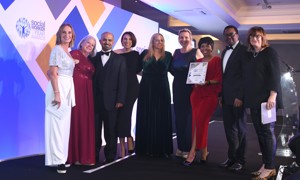 Nine people from the county council's Children, Young People and Learning team stand on stage together after being presented with the silver award.